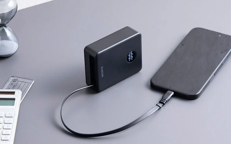 黒いバッテリーがスマホ充電中、ディスプレイ100%
